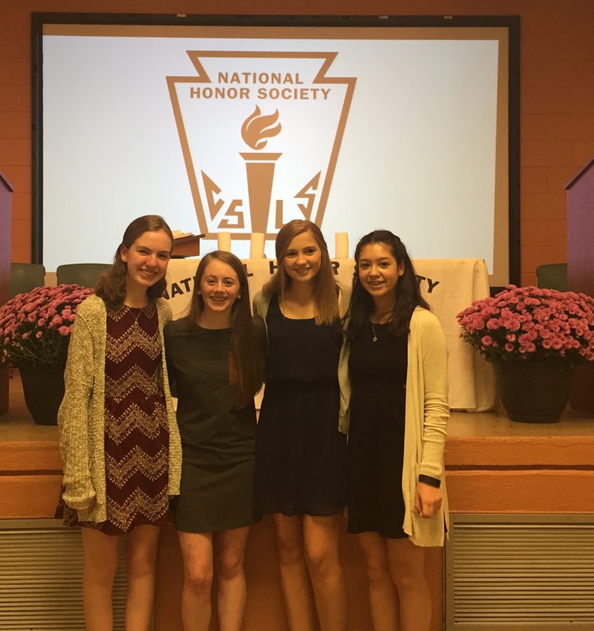 Photo Courtsey/ Mrs. Burke.
Katie Burke 18, Addy Donahue 18, Hailey Hoffman 18, and Katie Clancy 18 celebrate their induction in front of the NHS seal